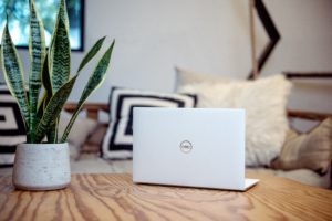 silver macbook on brown wooden table